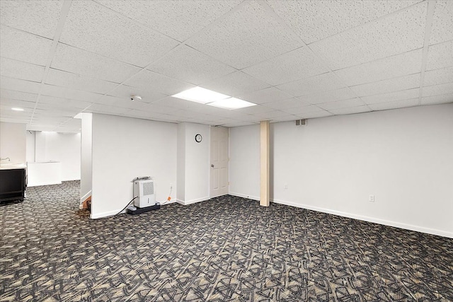 finished below grade area featuring carpet, a paneled ceiling, and baseboards