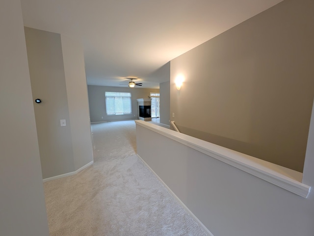 corridor featuring light carpet and baseboards