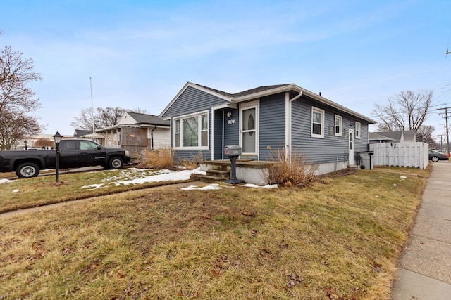 bungalow-style house with fence and a front yard