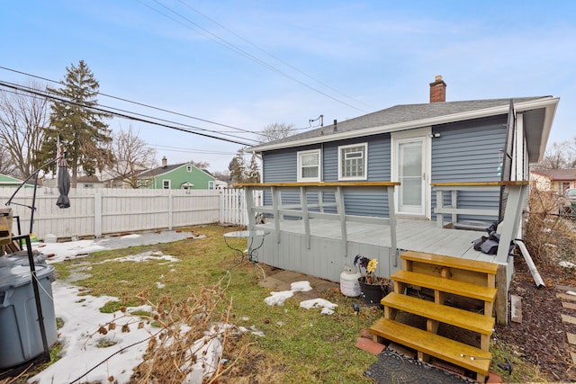 back of house with a deck, roof with shingles, a chimney, and a fenced backyard