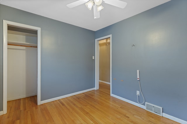 unfurnished bedroom featuring light wood finished floors, baseboards, visible vents, a ceiling fan, and a closet