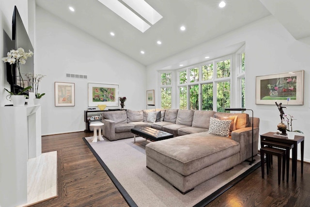 living room with dark wood-style floors, high vaulted ceiling, a skylight, and visible vents