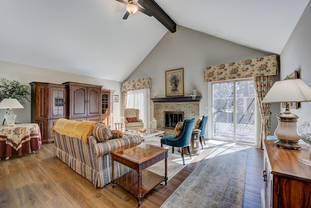 living room with beamed ceiling, a fireplace, wood finished floors, and a healthy amount of sunlight