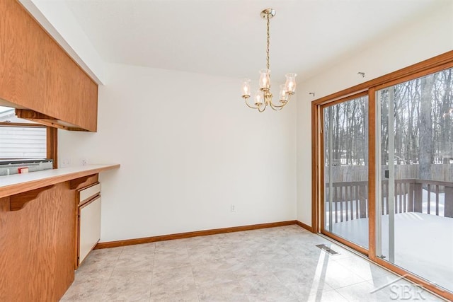 unfurnished dining area with baseboards, visible vents, and a notable chandelier