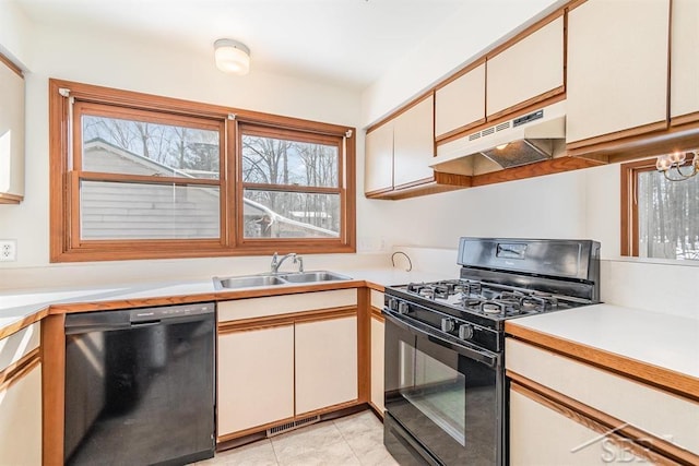 kitchen with a sink, black appliances, light countertops, and under cabinet range hood