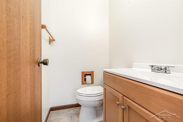 bathroom featuring baseboards, vanity, toilet, and tile patterned floors