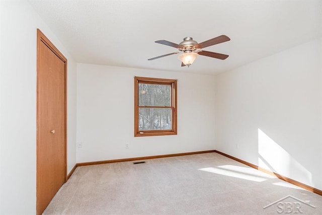 unfurnished room featuring a ceiling fan, baseboards, visible vents, and carpet flooring