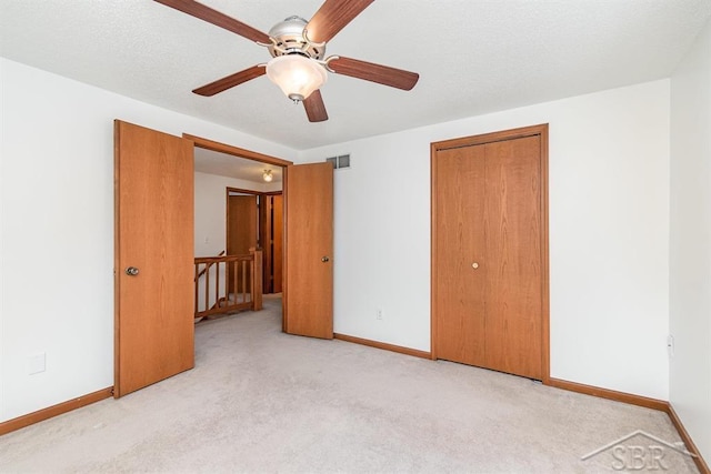 unfurnished bedroom with light carpet, visible vents, baseboards, and a closet