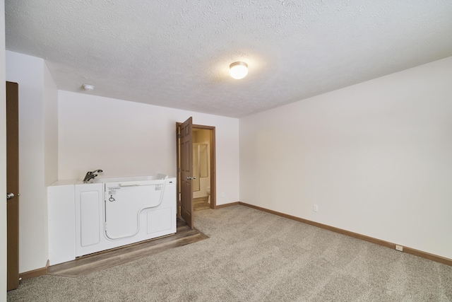 carpeted empty room featuring baseboards and a textured ceiling