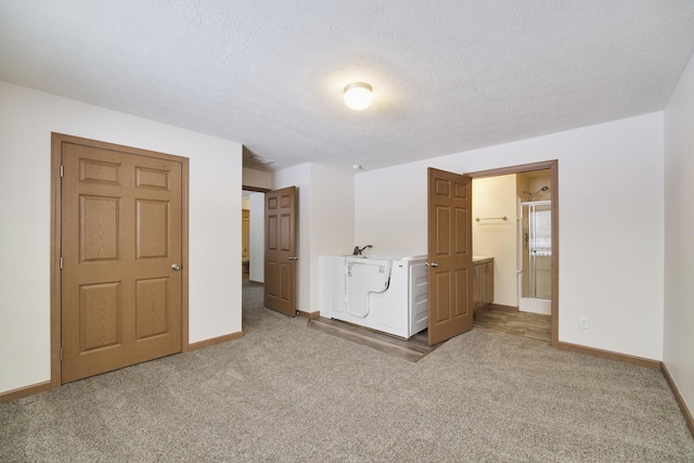 unfurnished bedroom with carpet flooring, connected bathroom, a textured ceiling, and baseboards