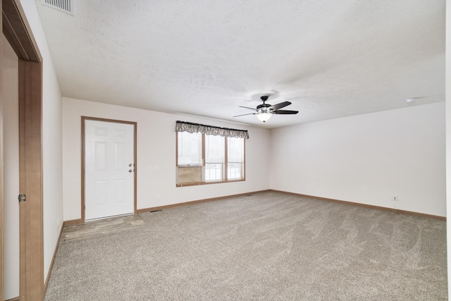 unfurnished room with carpet, a textured ceiling, visible vents, and baseboards