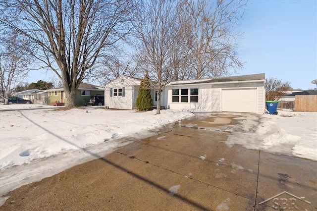 view of front facade with a garage, driveway, and fence