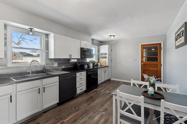 kitchen featuring a sink, black electric range, a wealth of natural light, dishwasher, and dark countertops