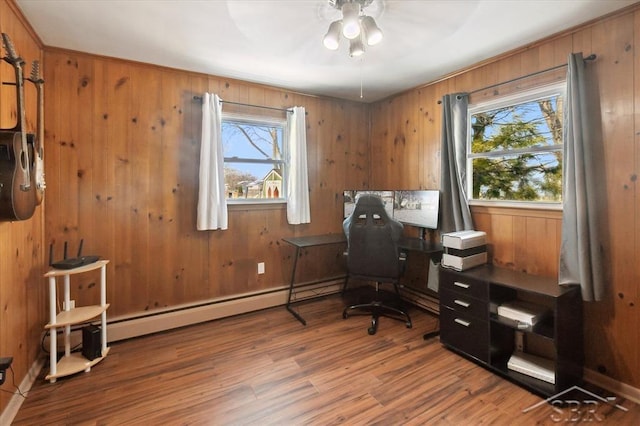 office with a baseboard radiator, wood walls, and wood finished floors