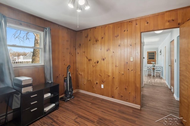 office featuring baseboards, dark wood-type flooring, and wooden walls