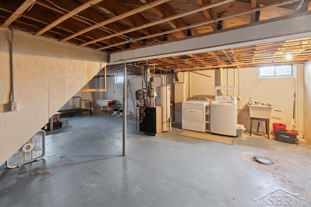 basement featuring gas water heater, a sink, and independent washer and dryer