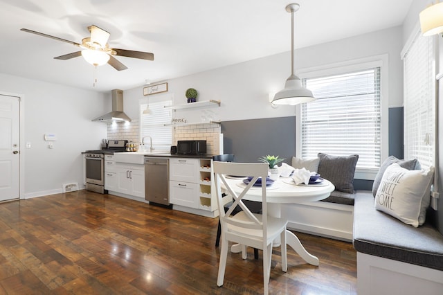 dining space featuring ceiling fan, breakfast area, dark wood finished floors, and baseboards