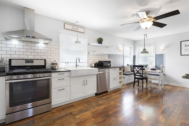 kitchen with extractor fan, stainless steel appliances, open shelves, dark countertops, and dark wood finished floors