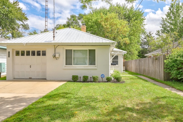 view of front of home featuring a front yard, metal roof, an attached garage, and fence