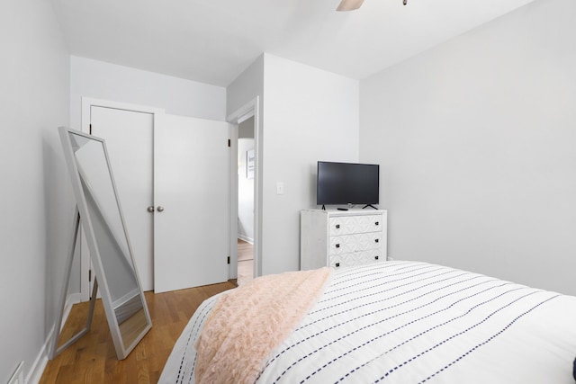 bedroom with ceiling fan, wood finished floors, and visible vents