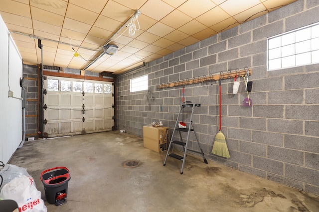 garage with concrete block wall and a garage door opener