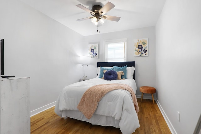 bedroom featuring a ceiling fan, baseboards, and wood finished floors