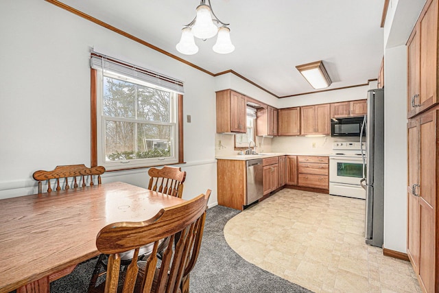 kitchen with crown molding, light countertops, an inviting chandelier, appliances with stainless steel finishes, and a sink