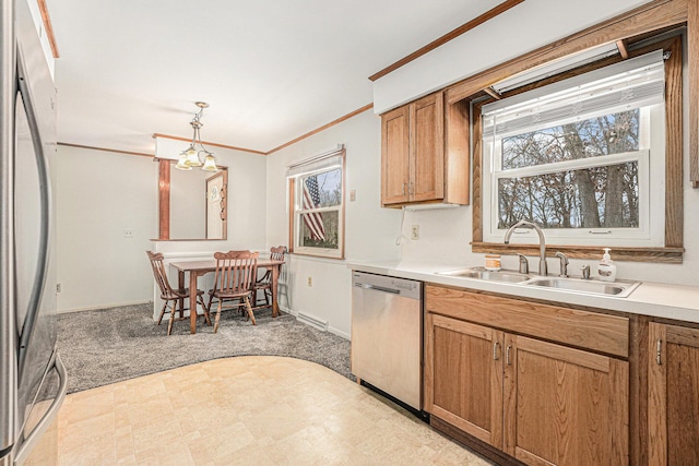 kitchen featuring ornamental molding, brown cabinets, stainless steel appliances, light countertops, and a sink