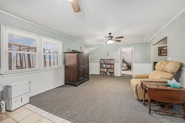 living area with a ceiling fan, light carpet, and crown molding