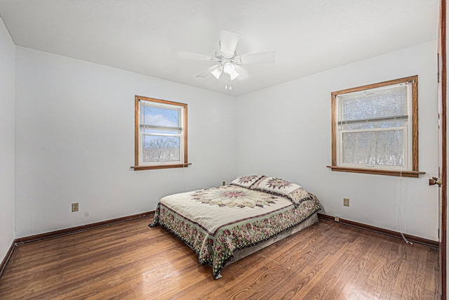 bedroom with ceiling fan, baseboards, and hardwood / wood-style floors