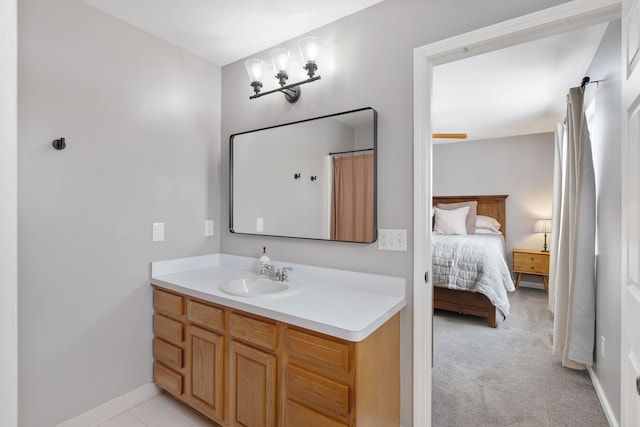 ensuite bathroom featuring connected bathroom, vanity, and baseboards