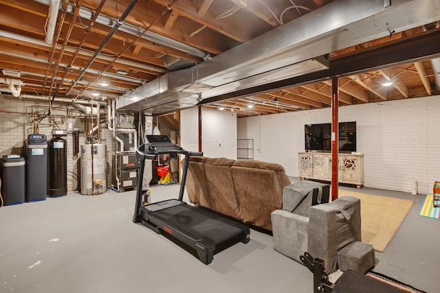 exercise area featuring heating unit, water heater, and brick wall