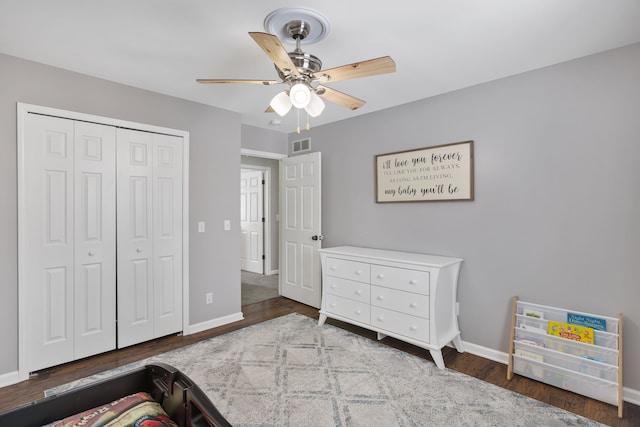 bedroom with baseboards, visible vents, a closet, and wood finished floors