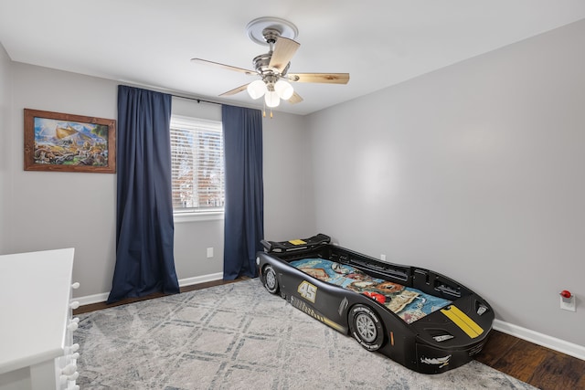 bedroom with ceiling fan, wood finished floors, and baseboards