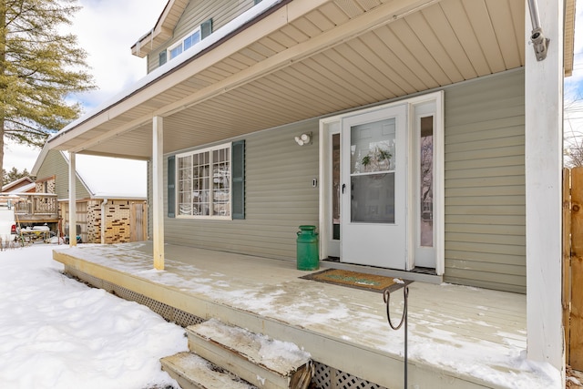 snow covered property entrance featuring a porch