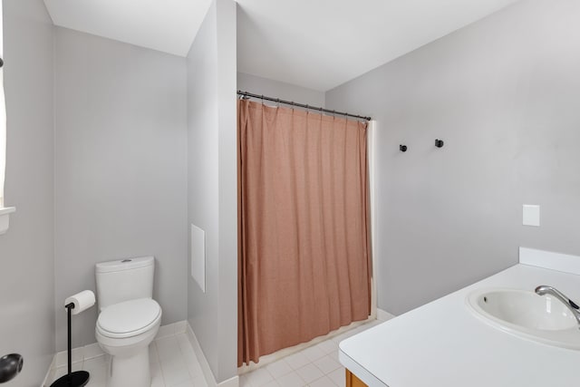 bathroom with toilet, vanity, a shower with curtain, baseboards, and tile patterned floors