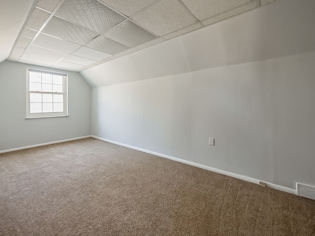 additional living space with carpet floors, visible vents, baseboards, and lofted ceiling