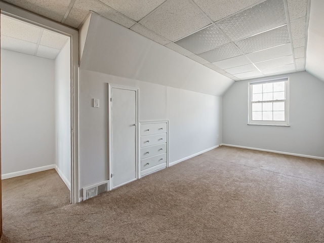 additional living space featuring lofted ceiling, baseboards, visible vents, and carpet flooring