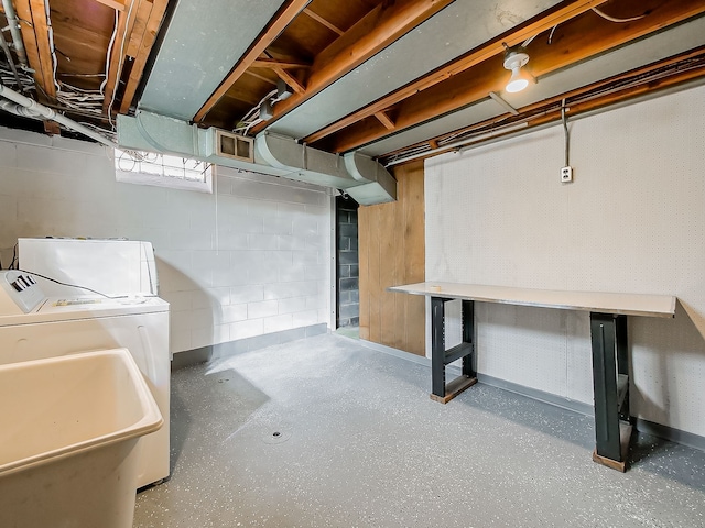 below grade area featuring a sink and washing machine and clothes dryer