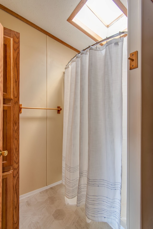 full bath with a shower with shower curtain, a textured ceiling, and tile patterned floors