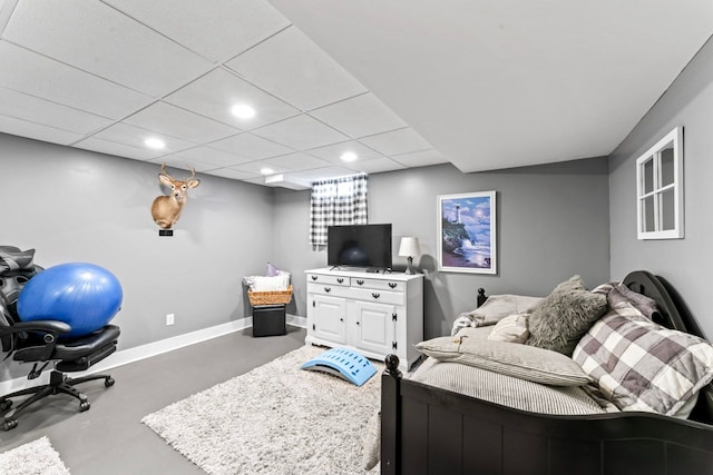 interior space with finished concrete flooring, recessed lighting, a paneled ceiling, and baseboards