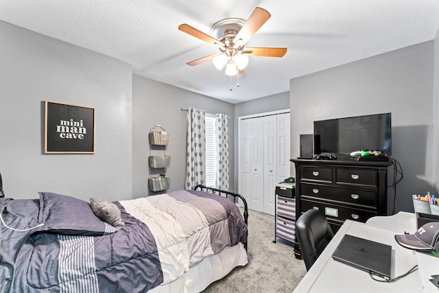 bedroom featuring a textured ceiling, ceiling fan, a closet, and carpet