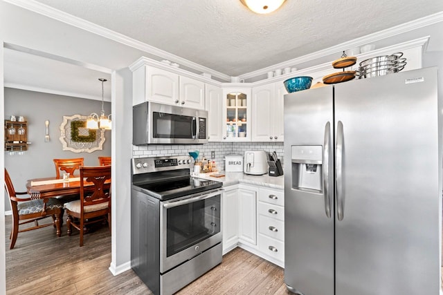 kitchen with stainless steel appliances, tasteful backsplash, white cabinetry, and light wood-style floors