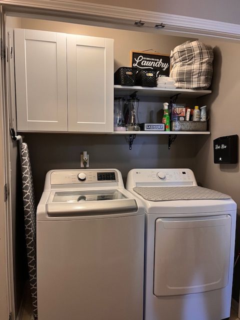 washroom featuring cabinet space and separate washer and dryer