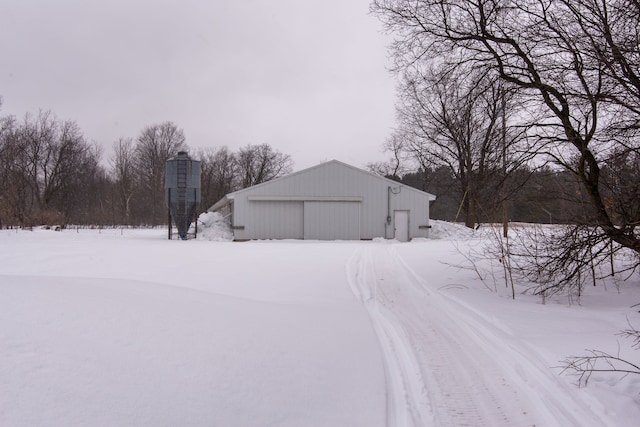 7214 S M 66, Mancelona, MI 49659 - yard covered in snow featuring an outdoor structure, an outbuilding, and a garage