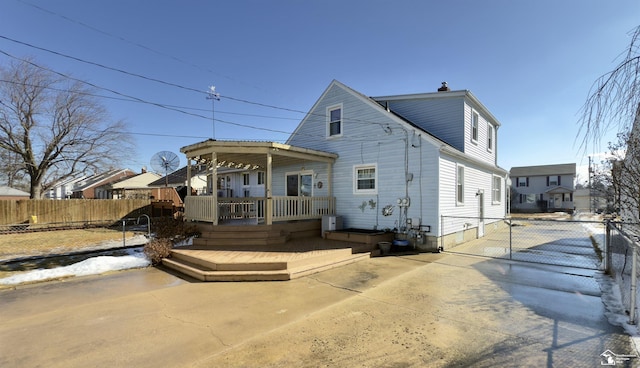 view of front of property featuring a wooden deck, a gate, and fence