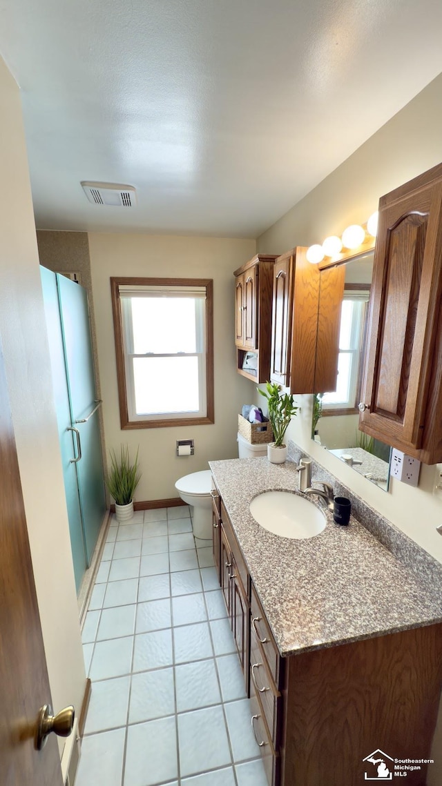 bathroom featuring visible vents, toilet, a shower stall, vanity, and tile patterned flooring