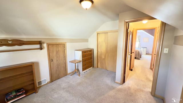 additional living space with visible vents, vaulted ceiling, and light carpet