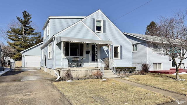 view of front facade featuring a front yard, a porch, a detached garage, and an outdoor structure