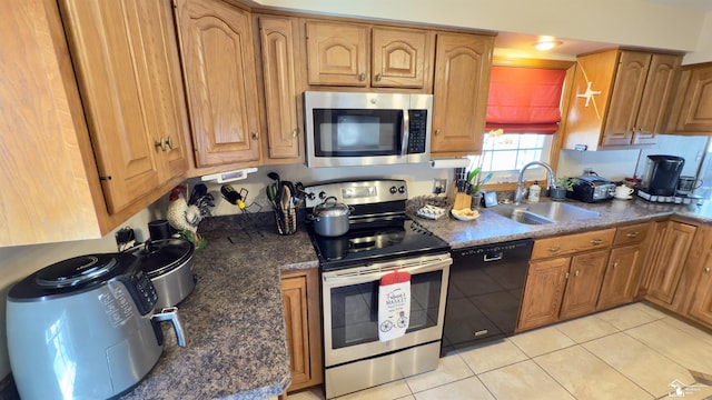 kitchen with appliances with stainless steel finishes, a sink, and brown cabinets